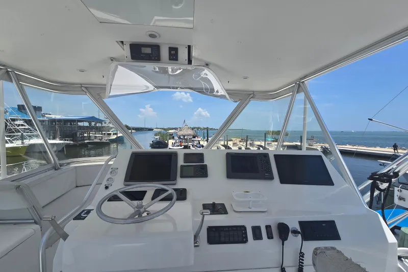 Slide: The Image of Helm of 2005 Cavileer 44 Convertible yacht with ocean view and marina backdrop. - 10