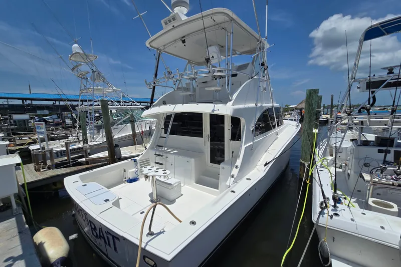 Slide: The Image of 2005 Cavileer 44 Convertible yacht docked at marina under clear blue sky. - 4