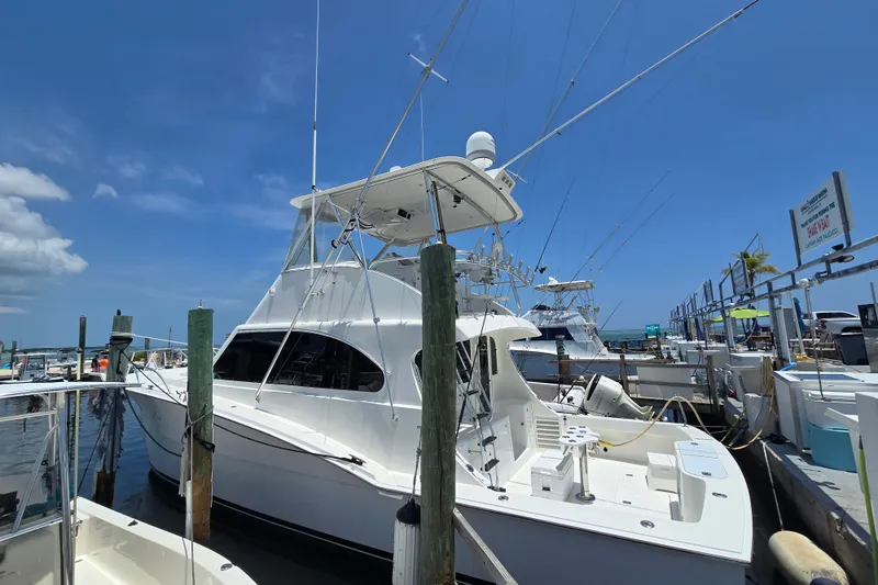 Slide: The Image of 2005 Cavileer 44 Convertible yacht docked at marina under clear blue sky. - 3