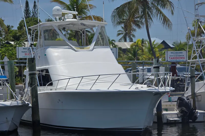 Slide: The Image of 2005 Cavileer 44 Convertible yacht docked at marina with palm trees in background. - 1