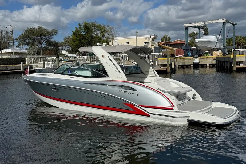 The Image of 2014 Formula 310 Bowrider boat docked in a marina under cloudy skies. - 1