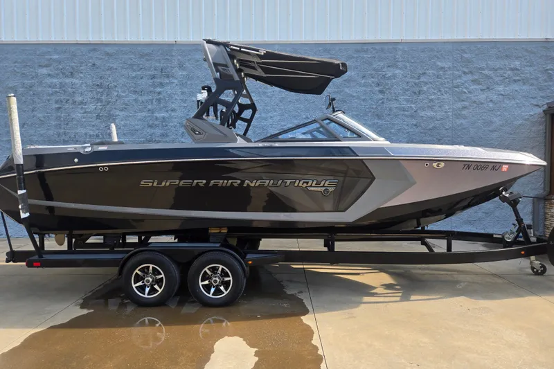 The Image of 2018 Nautique Super Air Nautique G25 boat on trailer, sleek design, parked outdoors. - 0