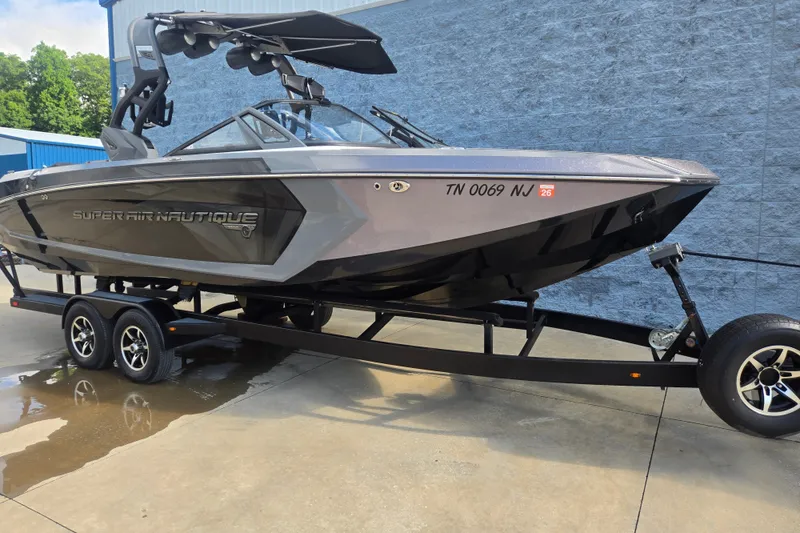 Slide: The Image of 2018 Nautique Super Air Nautique G25 boat on trailer, parked outdoors. - 2