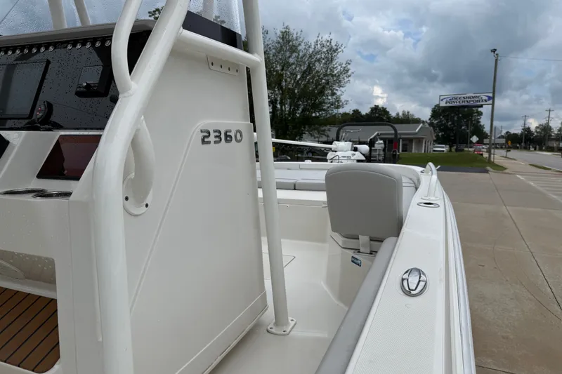 Slide: The Image of 2024 Ranger 2360 Bay boat, sleek design, parked outdoors under cloudy sky. - 34
