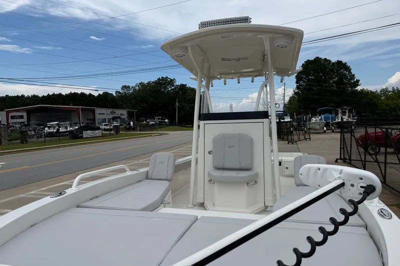 Slide: The Image of 2024 Ranger 2360 Bay boat with sleek design, docked near dealership under clear sky. - 22