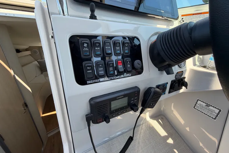 Slide: The Image of Control panel of 2023 Regal 28 Express boat with switches and Garmin radio. - 18