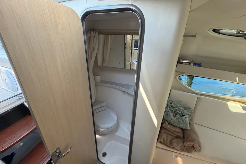Slide: The Image of 2023 Regal 28 Express boat interior with compact bathroom and cozy seating area. - 25