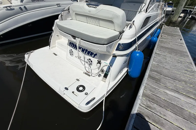 Slide: The Image of 2023 Regal 28 Express boat docked, featuring a spacious rear deck and blue fenders. - 6