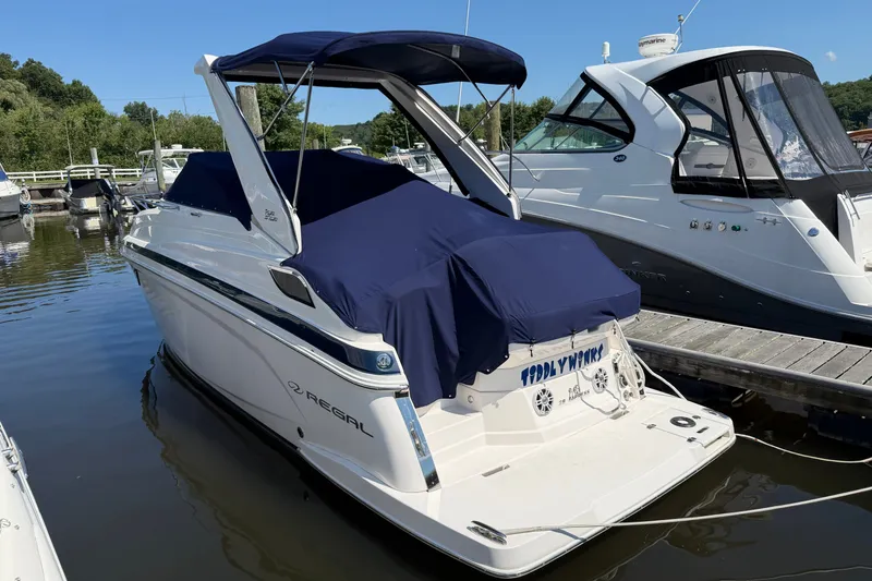 Slide: The Image of 2023 Regal 28 Express boat docked, featuring a navy blue cover and sleek design. - 29