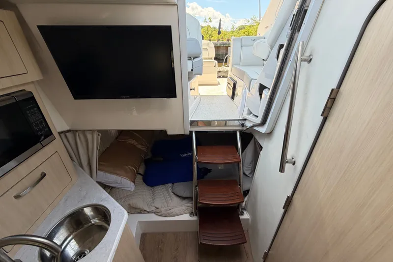 Slide: The Image of Interior of 2023 Regal 28 Express boat with kitchenette, TV, and cozy sleeping area. - 27