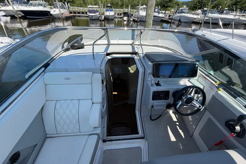 Slide: The Image of 2023 Regal 28 Express boat interior with helm, seating, and marina view. - 20