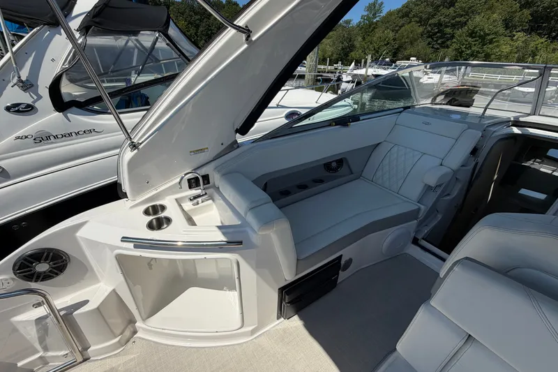 Slide: The Image of 2023 Regal 28 Express boat interior with seating and cup holders, docked at marina. - 11