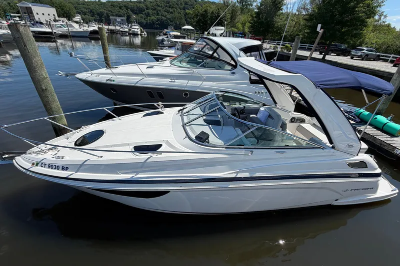 Slide: The Image of 2023 Regal 28 Express boat docked in a marina, surrounded by other boats. - 1