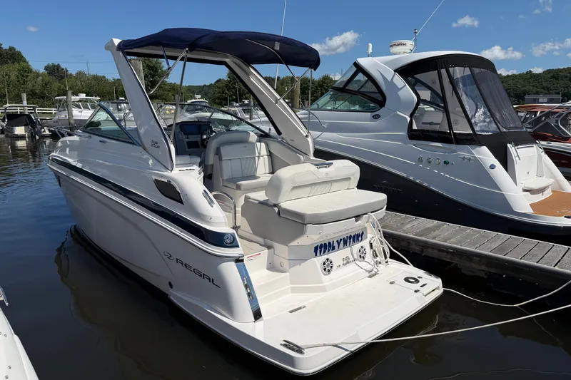 Slide: The Image of 2023 Regal 28 Express boat docked at marina under clear blue sky. - 3
