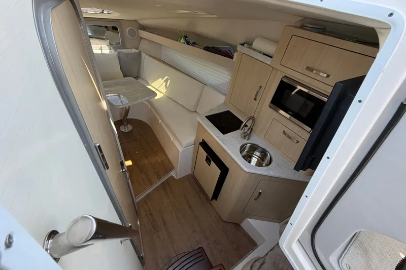 Slide: The Image of 2023 Regal 28 Express cabin interior with kitchenette, seating, and modern amenities. - 21