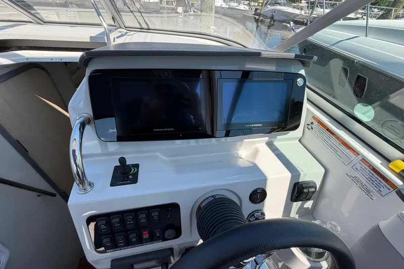 Slide: The Image of 2023 Regal 28 Express boat dashboard with dual Volvo Penta displays and control panel. - 17