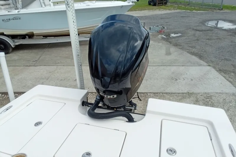 Slide: The Image of Outboard motor on 2006 Pathfinder 2200 Tournament Edition boat, docked near another vessel. - 23