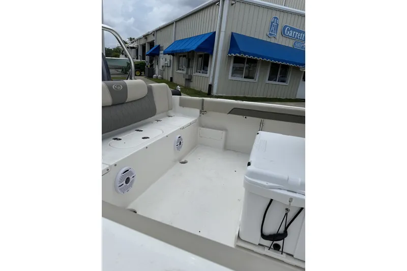 Slide: The Image of The image shows the cockpit of a Key West 239 FS boat. It features white seating and speakers. - 3