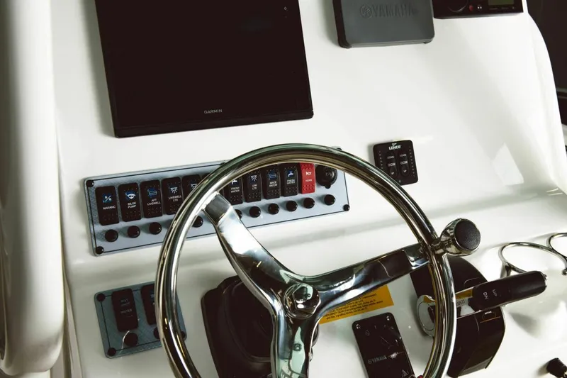 Slide: The Image of Manufacturer Provided Image: 2025 Key West 239 FS boat dashboard with steering wheel and control panel. - 9