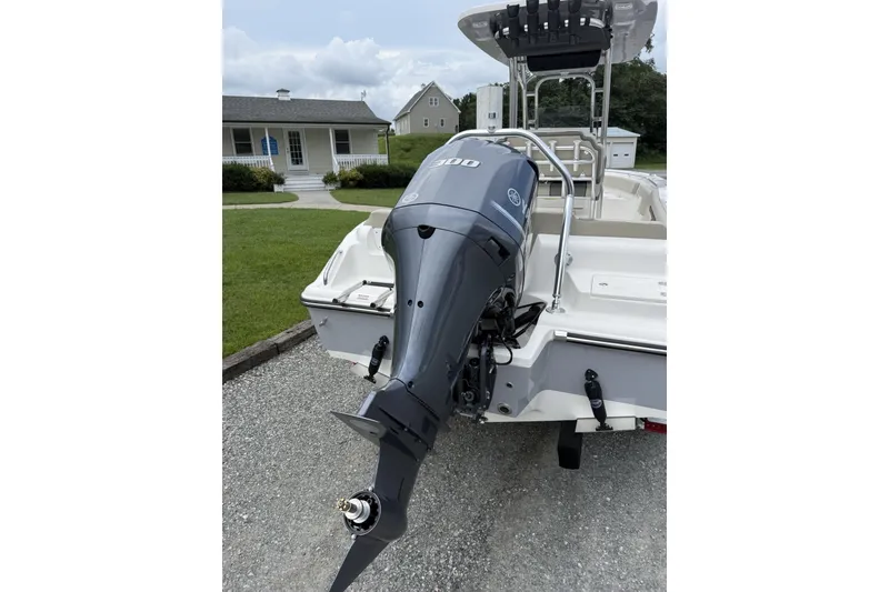 Slide: The Image of A Key West 239 FS boat with a powerful outboard motor, parked on a gravel path. - 5