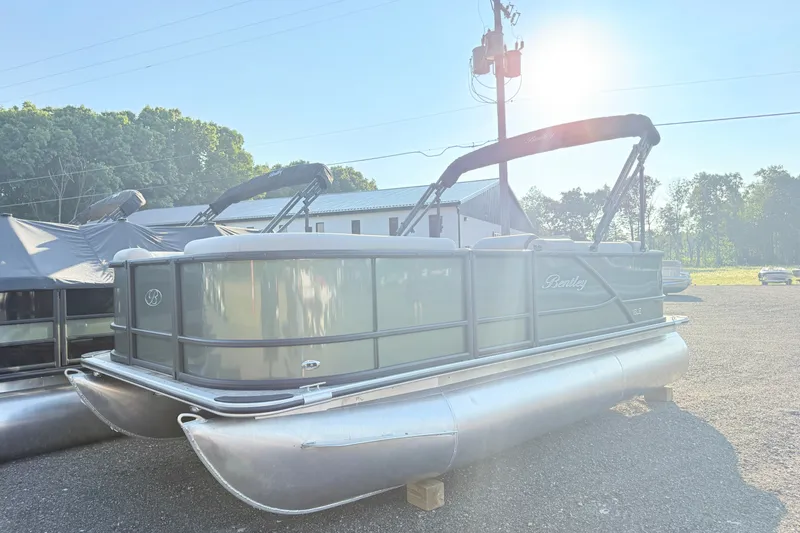 Slide: The Image of 2027 Bentley Pontoons LE 180CR pontoon boat in a sunny outdoor setting. - 2