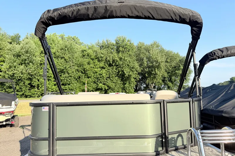 Slide: The Image of 2027 Bentley Pontoons LE 180CR with canopy, parked outdoors near trees. - 4