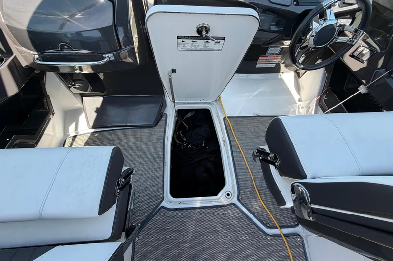 Slide: The Image of 2018 Monterey 298SS Super Sport boat interior with open storage compartment and steering wheel. - 24