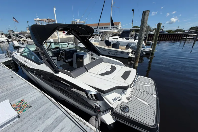 Slide: The Image of 2018 Monterey 298SS Super Sport boat docked at marina, featuring sleek design and spacious seating. - 4
