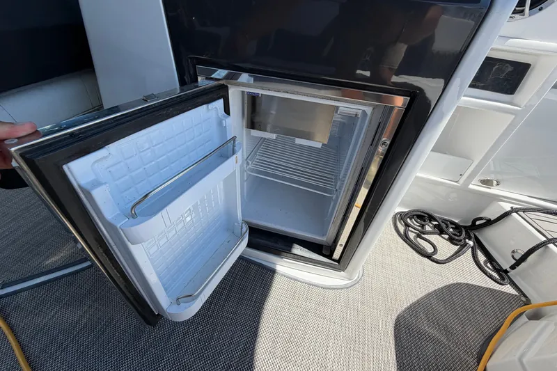 Slide: The Image of Open mini fridge on 2018 Monterey 298SS Super Sport boat, showcasing interior storage space. - 17