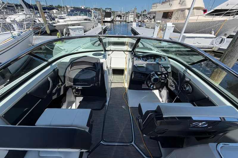 Slide: The Image of 2018 Monterey 298SS Super Sport boat interior at marina, showcasing seating and dashboard. - 19