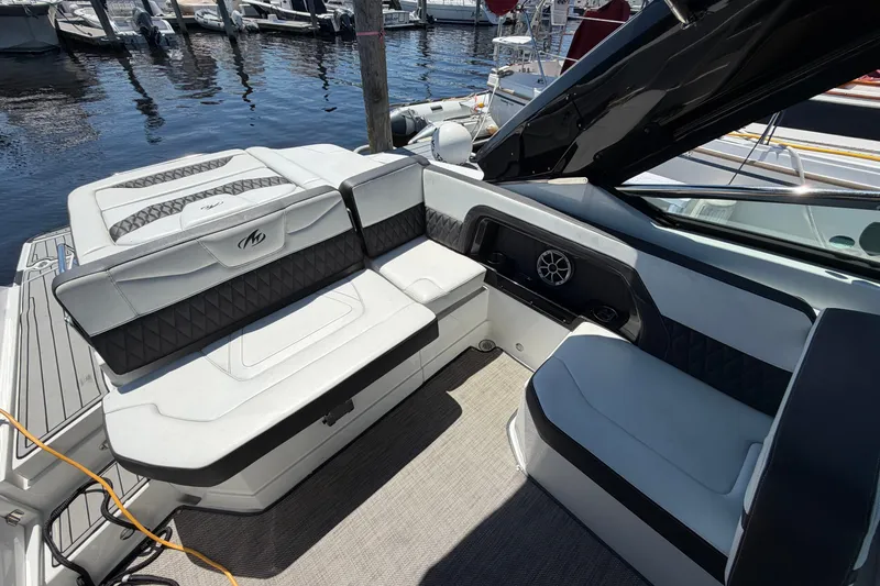 Slide: The Image of 2018 Monterey 298SS Super Sport boat interior with luxurious seating at a marina. - 14