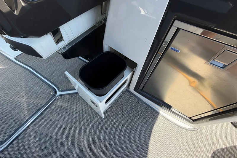 Slide: The Image of 2018 Monterey 298SS Super Sport boat interior with built-in trash compartment and mini fridge. - 18