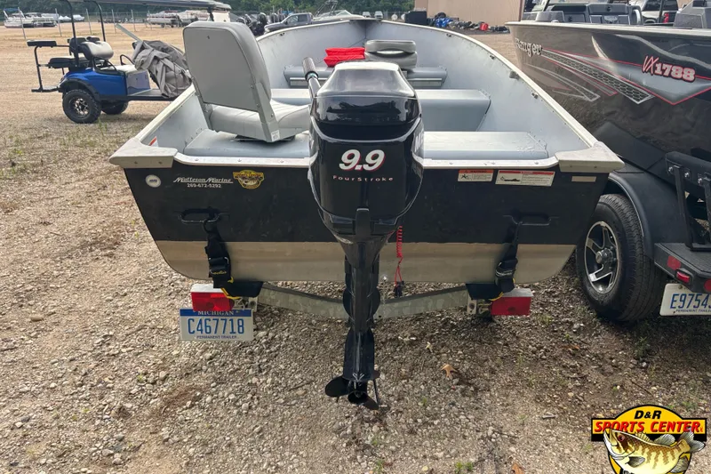 Slide: The Image of 2011 Lund WD 14 boat with 9.9 horsepower motor, parked on gravel. - 2