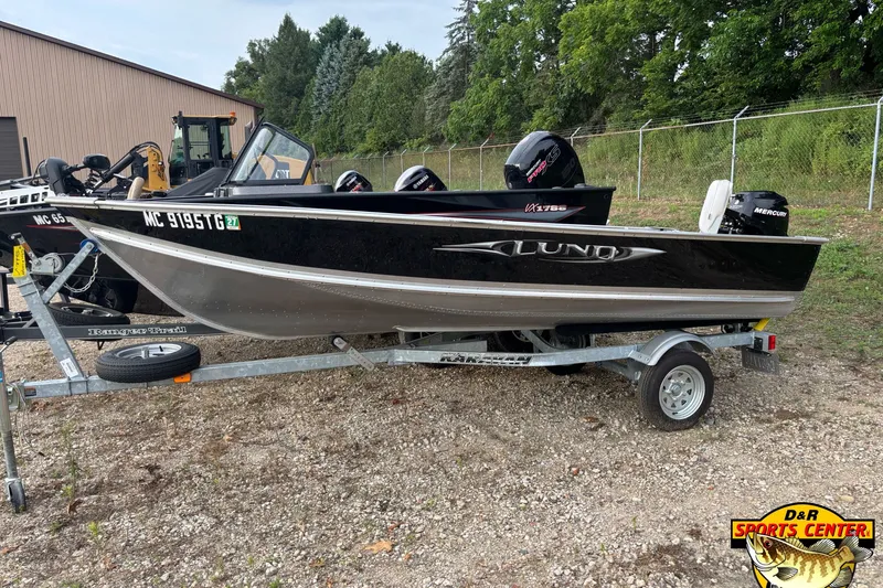 The Image of 2011 Lund WD 14 boat on trailer, parked outdoors near trees and a building. - 0