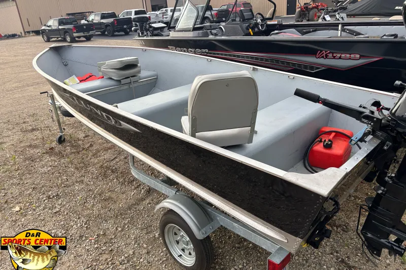 Slide: The Image of 2011 Lund WD 14 boat on trailer at D&R Sports Center, featuring seating and outboard motor. - 3