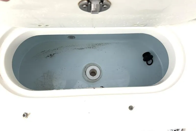 Slide: The Image of Livewell compartment in 2024 Key West 239 DFS boat, featuring clean interior and drain plug. - 31
