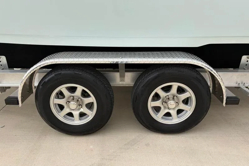 Slide: The Image of Trailer wheels of a 2024 Key West 239 DFS boat on a concrete surface. - 35