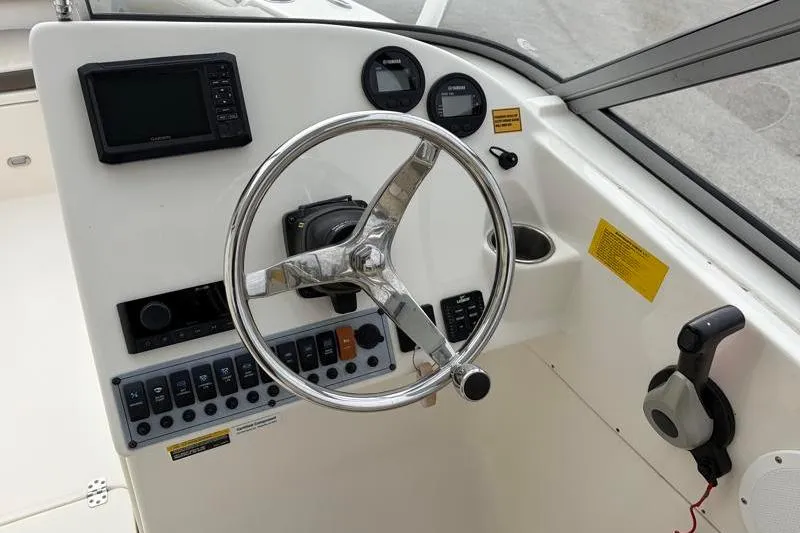 Slide: The Image of 2024 Key West 239 DFS boat dashboard with steering wheel and control panel. - 18