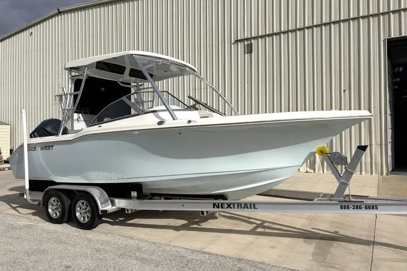 Slide: The Image of 2024 Key West 239 DFS boat on trailer outside a large warehouse. - 2