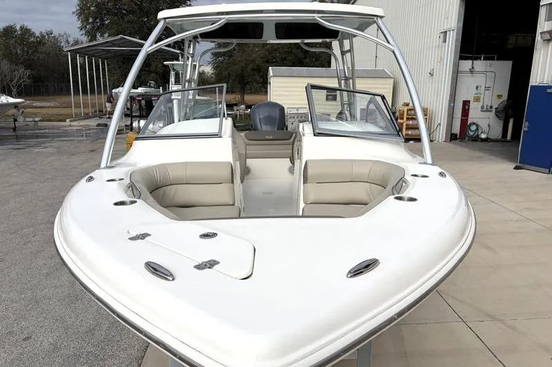 Slide: The Image of 2024 Key West 239 DFS boat with open bow seating, docked near a warehouse. - 6