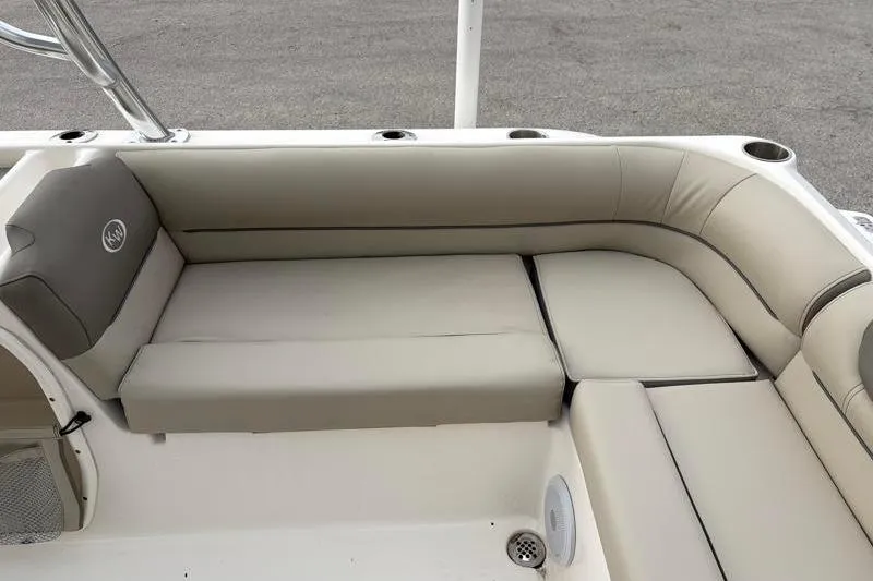 Slide: The Image of 2024 Key West 239 DFS boat interior with beige cushioned seating and cup holders. - 29