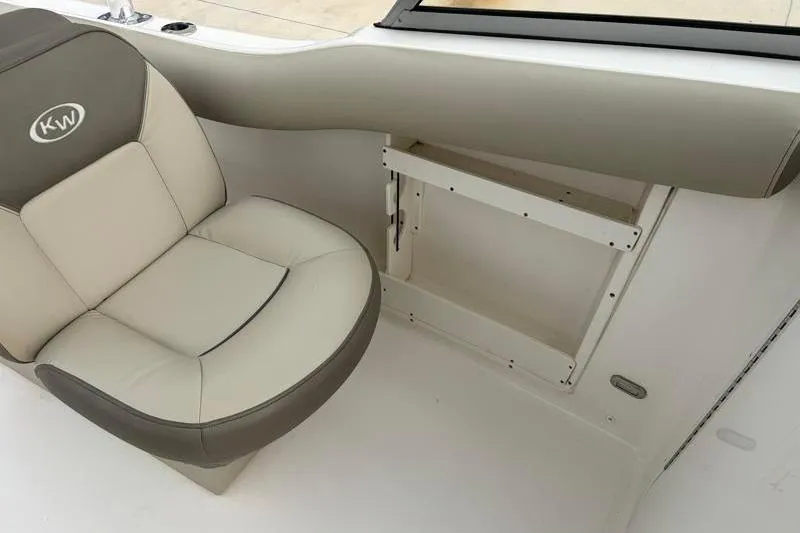 Slide: The Image of 2024 Key West 239 DFS boat interior with cushioned seating and storage compartment. - 25