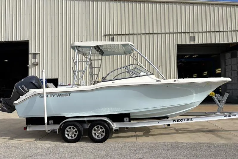 Slide: The Image of 2024 Key West 239 DFS boat on trailer outside industrial building. - 1