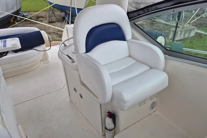Slide: The Image of Captain's seat on 2005 Sea Ray 340 Sundancer boat, featuring white and blue upholstery. - 9