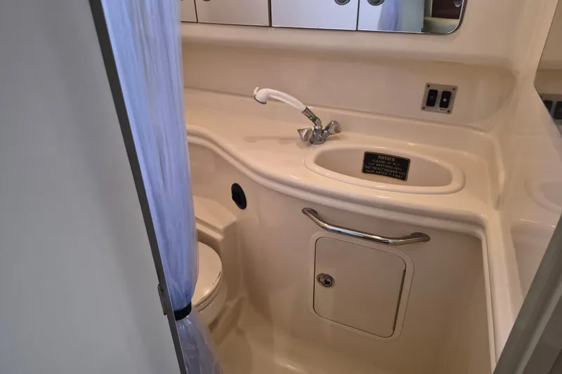 Slide: The Image of 2005 Sea Ray 340 Sundancer bathroom with sink, toilet, and storage cabinet. - 22