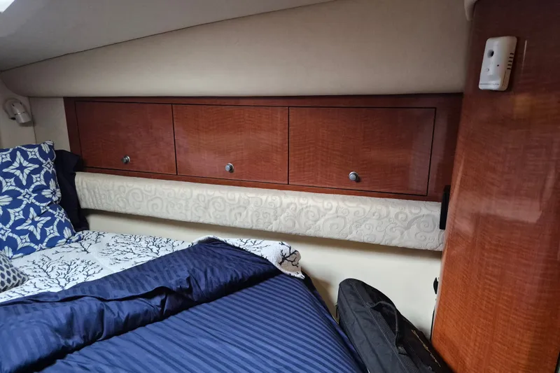 Slide: The Image of Interior cabin of 2005 Sea Ray 340 Sundancer with wooden cabinets and patterned bedding. - 19