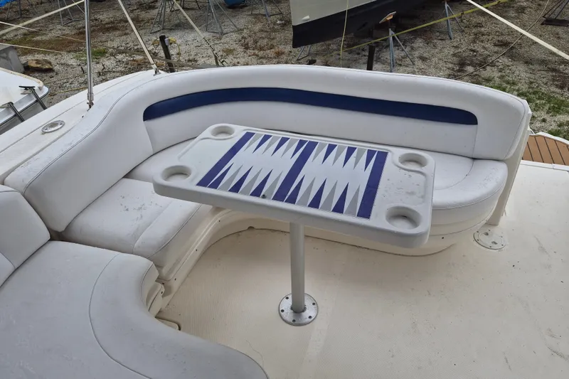 Slide: The Image of 2005 Sea Ray 340 Sundancer boat interior with white seating and a backgammon table. - 13