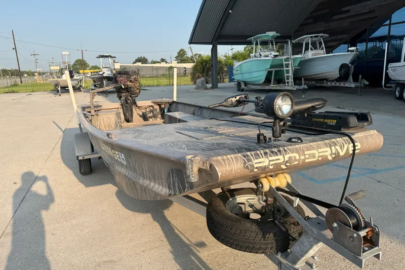 Slide: The Image of 2015 Custom Pro Drive 1754 boat on trailer, parked outdoors near other boats. - 5