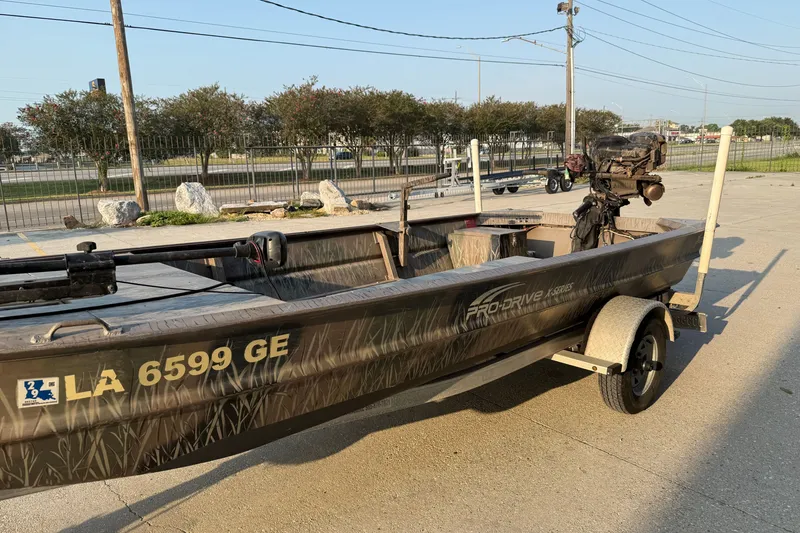 Slide: The Image of 2015 Custom Pro Drive 1754 boat on trailer, parked outdoors in a sunny setting. - 7