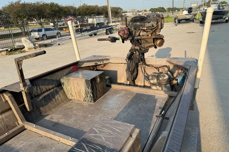 Slide: The Image of 2015 Custom Pro Drive 1754 boat with camouflage interior and outboard motor in a parking area. - 12